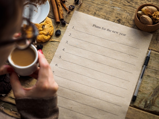 La niña toma café y hace planes para el nuevo año.