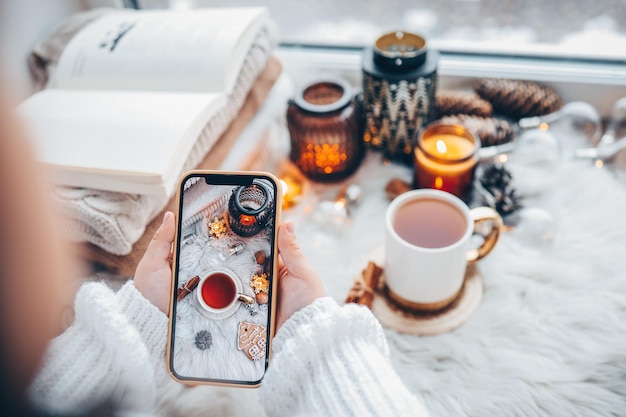 La niña toma una foto de la decoración navideña, el teléfono está en sus manos.