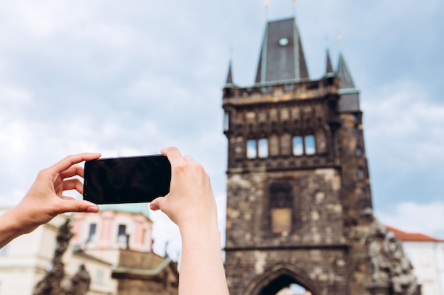 Una niña toma una foto en el teléfono del Puente de Carlos de Praga