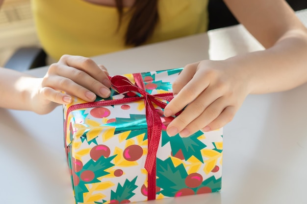 La niña toma un regalo del empaque y desata la cinta.