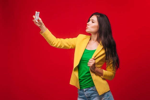 La niña se toma una selfie en un teléfono móvil.