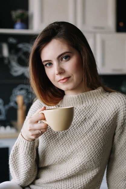 niña tomando café en la cocina en casa por la mañana