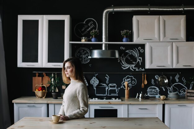 niña tomando café en la cocina en casa por la mañana