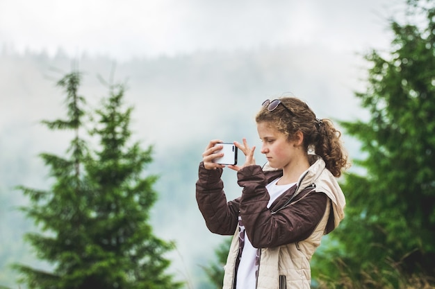 Niña tomando fotografías de las montañas