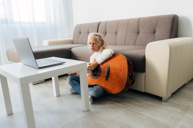 Foto niña tomando una lección de guitarra en línea