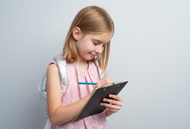 Niña tomando notas con lápiz