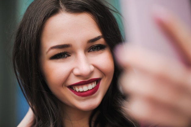 Niña tomar selfie de manos con teléfono en la ciudad de verano