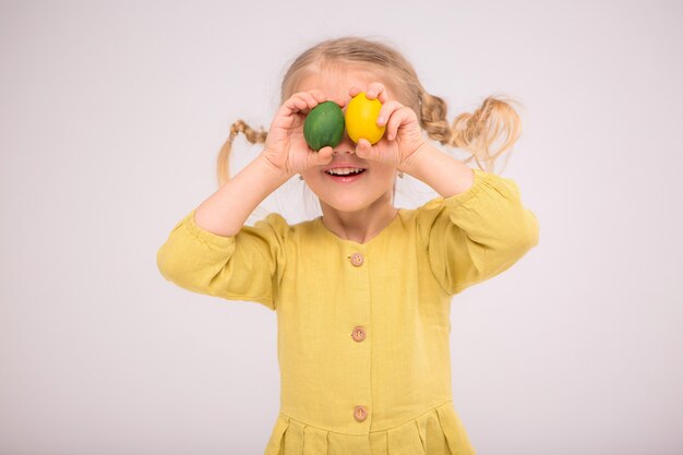 la niña tooddler hace malabares con los huevos y sonríe alegremente