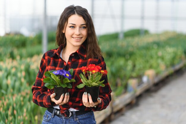 Niña, trabajadora con flores en invernadero