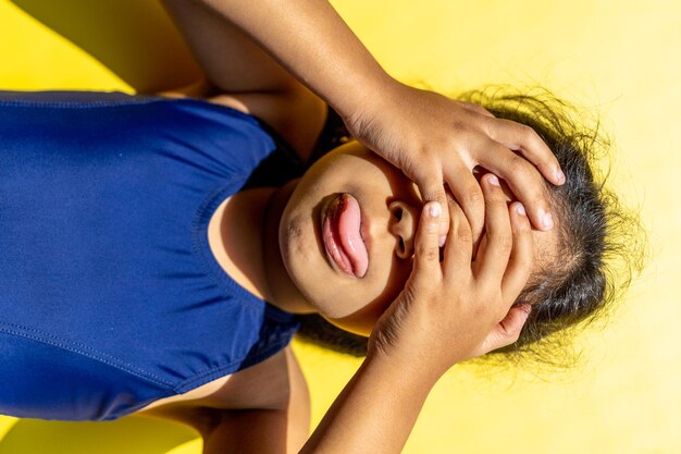 Niña con traje de baño está recibiendo el sol