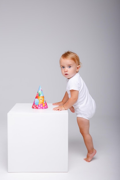 una niña con un traje blanco celebra su cumpleaños con un fondo blanco