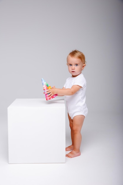 una niña con un traje blanco celebra su cumpleaños con un fondo blanco