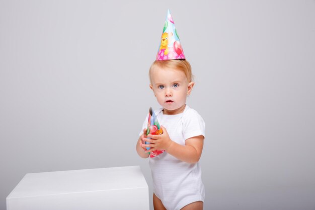 una niña con un traje blanco celebra su cumpleaños con un fondo blanco