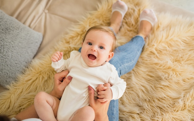 Una niña con un traje blanco yace sobre los pies de su madre