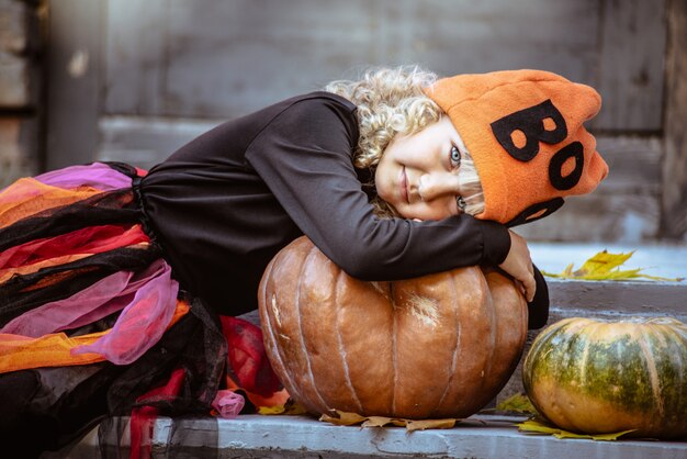 Niña en traje de bruja celebrar Halloween al aire libre y divertirse.