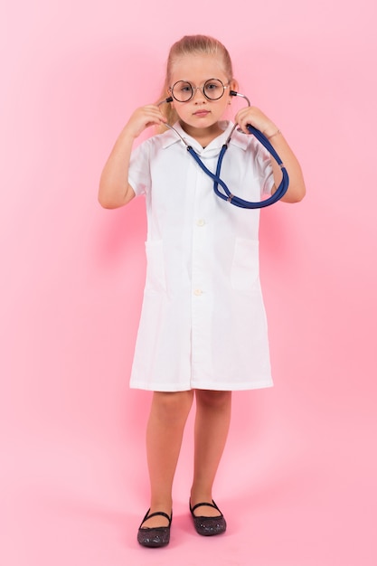 Niña en traje de médico con estetoscopio