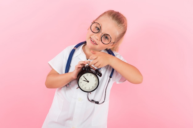 Niña en traje de médico con relojes