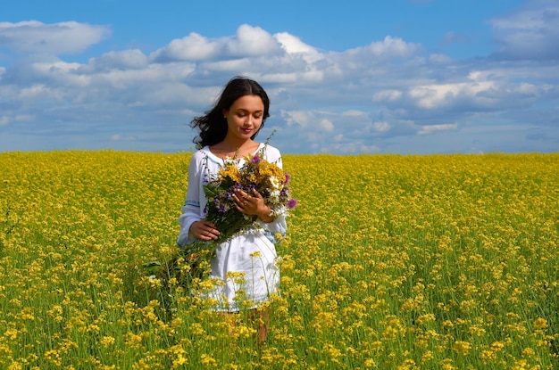 Una niña con el traje nacional de Ucrania en un campo de flores.