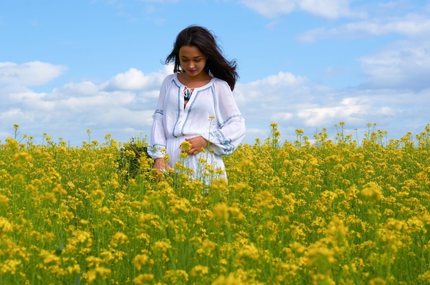 Una niña con el traje nacional de Ucrania en un campo de flores.