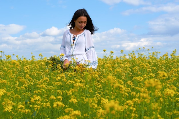 Una niña con el traje nacional de Ucrania en un campo de flores.