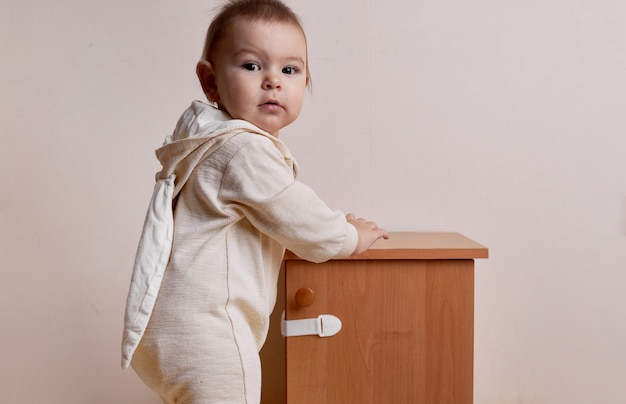 Niña tratando de abrir el gabinete con la cerradura de seguridad para bebés