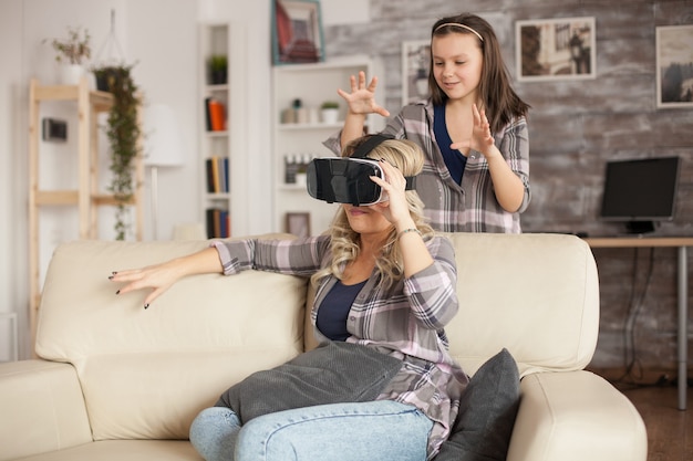 Niña tratando de asustar a su madre mientras usa auriculares virtuales.