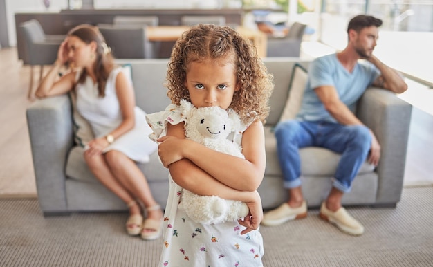 Niña triste peleando con los padres pensando en el divorcio en la sala de estar y el niño asustado de la familia se separará. Deprimido, tóxico, preocupado por el hogar, niño con necesidades de apoyo, madre molesta y padre frustrado en una discusión.