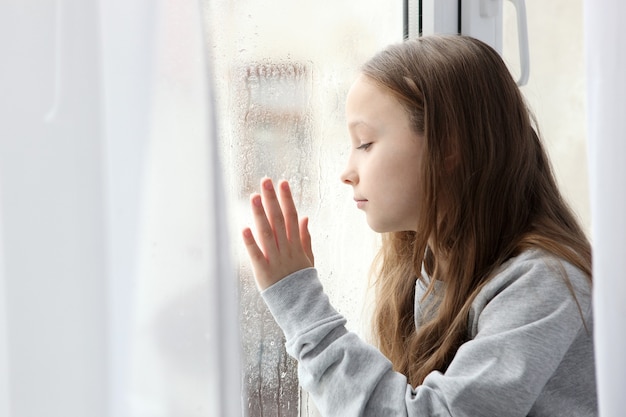 Niña triste solitaria en casa niño alarmado entristecido solo en casa