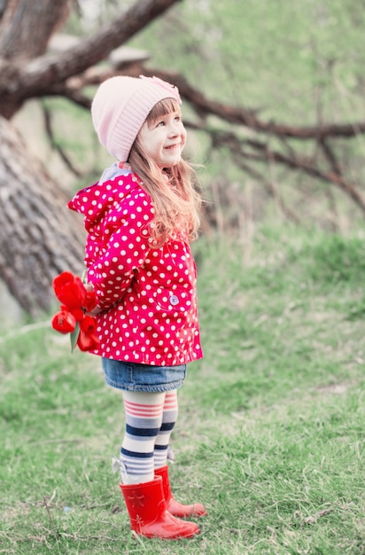 Niña con tulipanes al aire libre