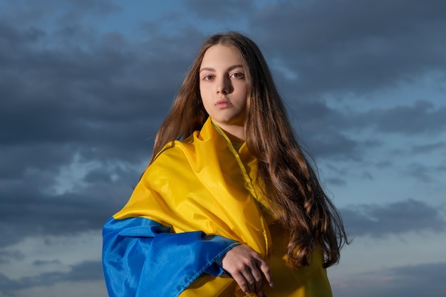 Niña ucraniana adolescente patriótica con bandera azul amarilla de ucrania