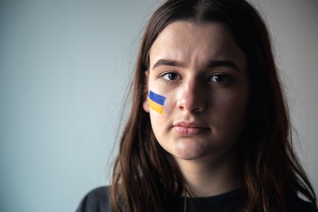 Una niña ucraniana con una bandera pintada de ucrania en su rostro.