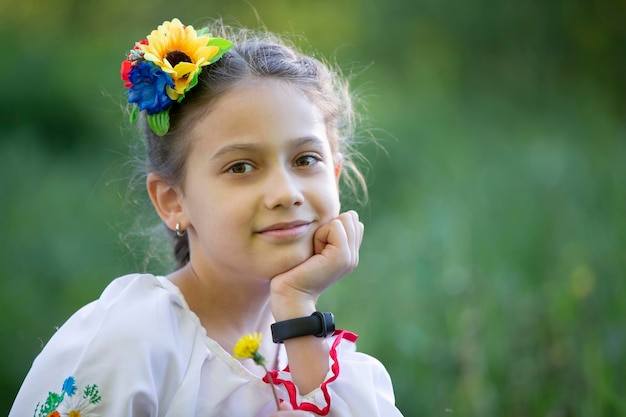 Una niña ucraniana y bielorrusa con una camisa bordada en un fondo de verano