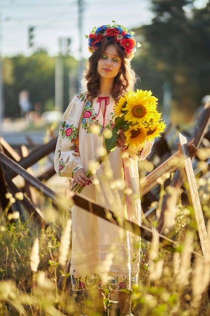 Una niña ucraniana con un vestido vyshyvanka nacional ucraniano con un ramo de girasoles, antitanque