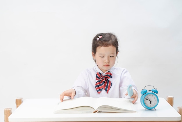 La niña en uniforme escolar está haciendo su tarea.