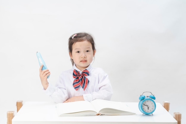 La niña en uniforme escolar está haciendo su tarea.