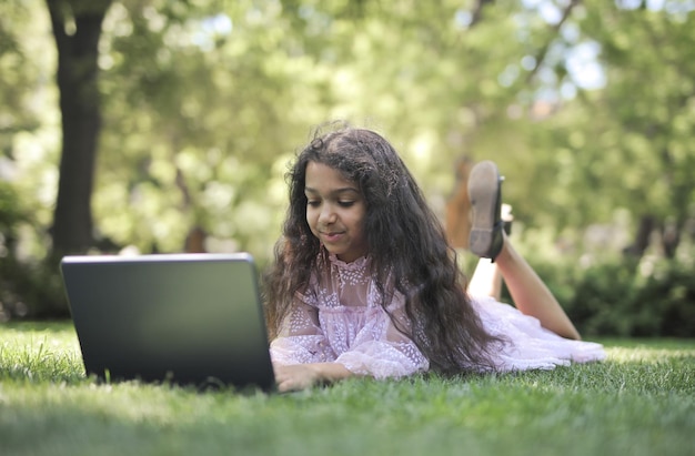Foto niña usa una computadora en un parque