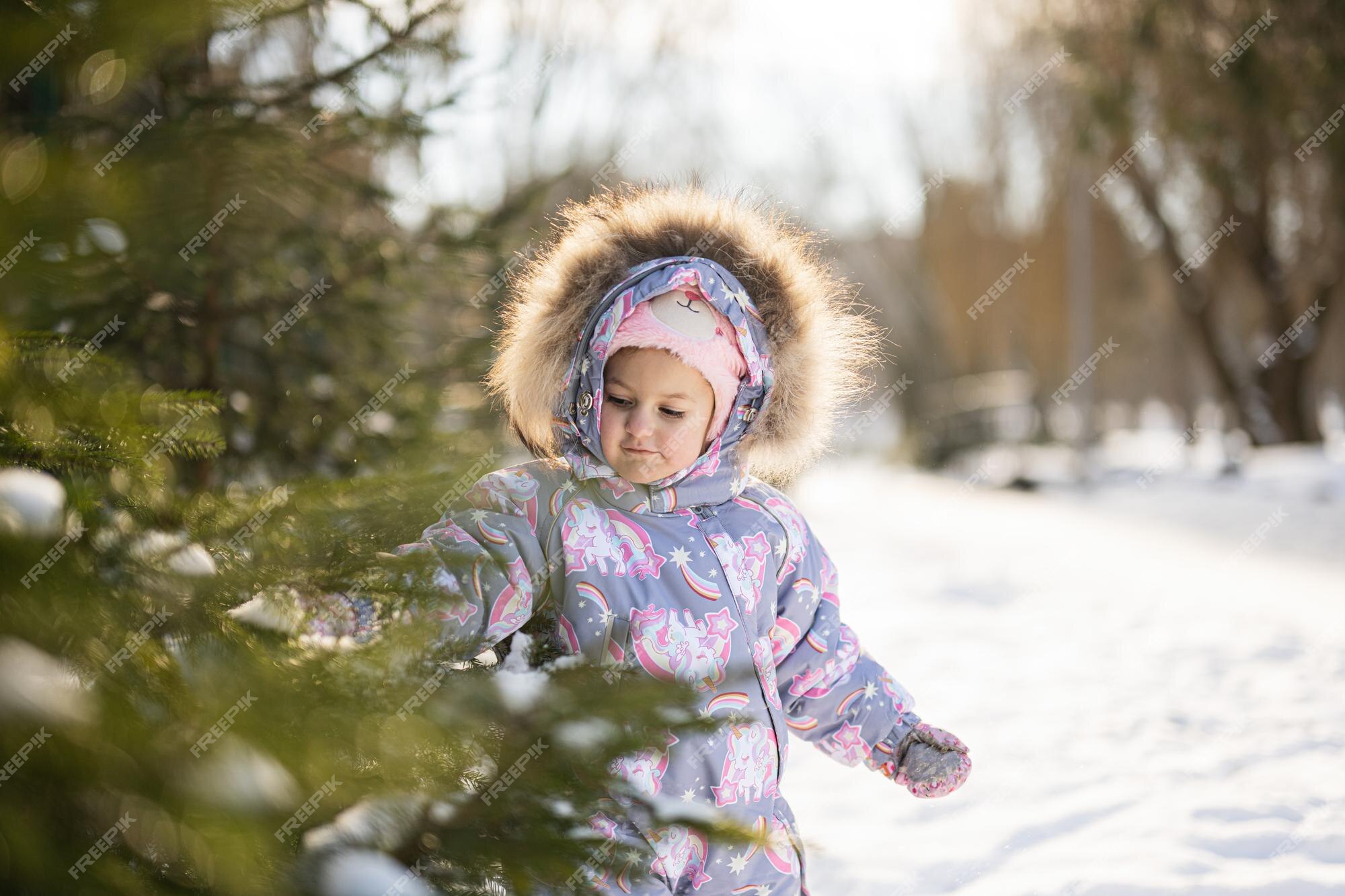 La niña usa traje nieve para niños en un día de invierno helado | Foto