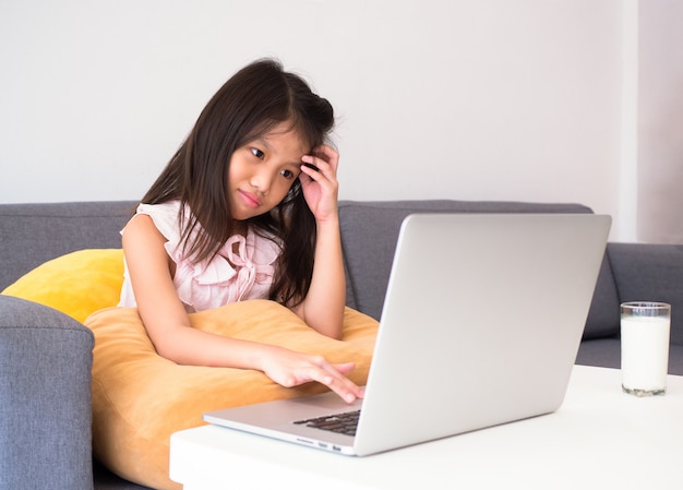 Foto niña usando laptop para estudiar lecciones en línea