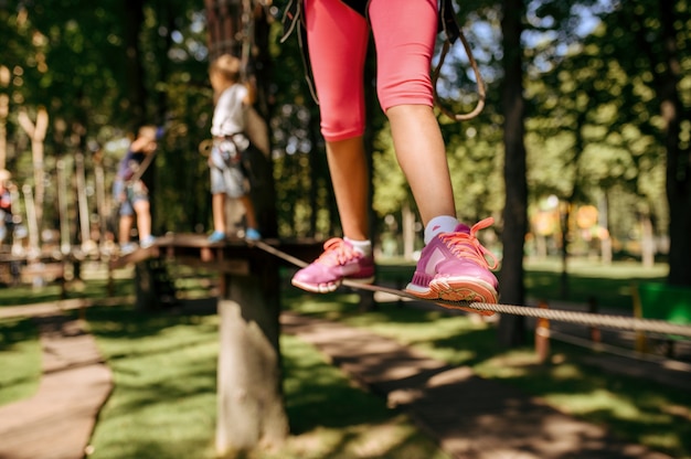 Foto niña valiente sube en el parque de cuerdas