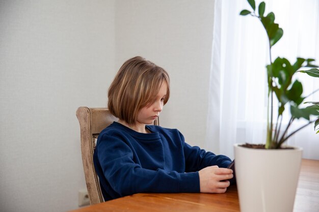 Una niña ve una película en una tableta en una mesa