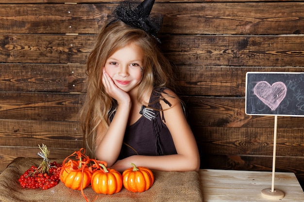 Una niña vestida de bruja con adornos de Halloween.