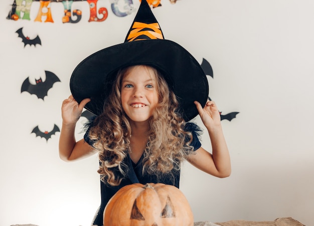 Niña vestida de bruja con calabaza. Víspera de Todos los Santos. calabaza para halloween