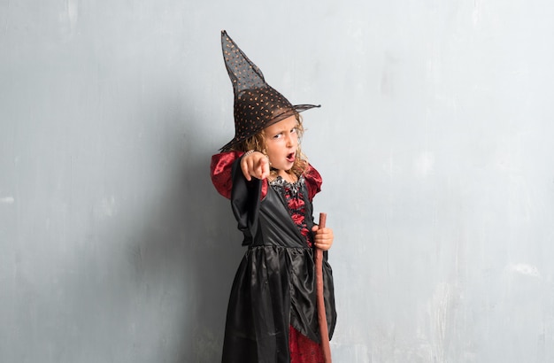 Niña vestida de bruja para las vacaciones de halloween y gritando