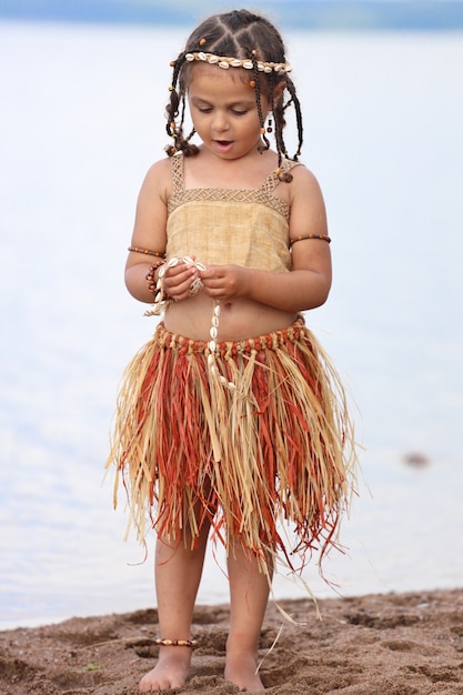 Niña vestida como nativa al aire libre en verano. Foto de alta calidad