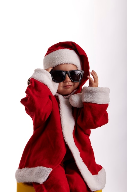 Una niña vestida como Santa Claus sobre un fondo blanco.