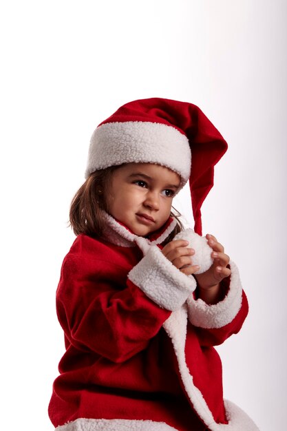 Una niña vestida como Santa Claus sobre un fondo blanco.