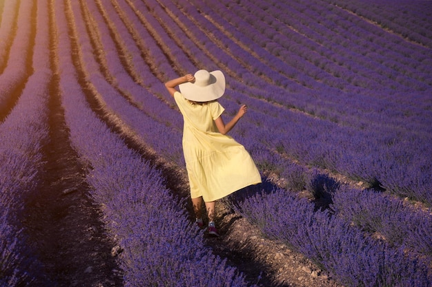 Una niña con un vestido amarillo en un campo de lavanda