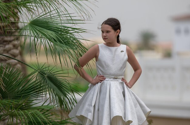 Foto niña con un vestido blanco en los trópicos