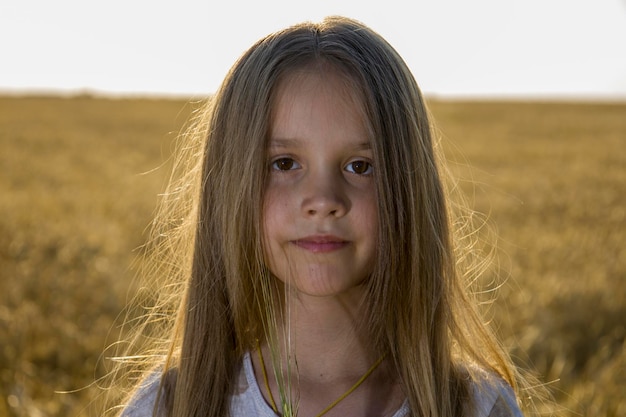 Una niña con un vestido en un campo de trigo.