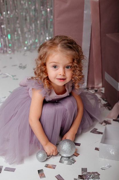 Foto niña en un vestido elegante con globos y confeti